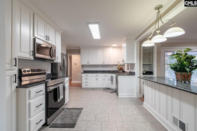 kitchen featuring stainless steel appliances, white cabinets, dark stone countertops, pendant lighting, and crown molding