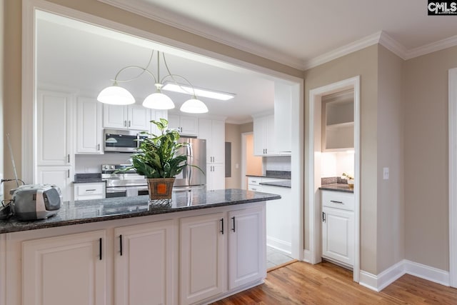 kitchen with white cabinets, dark stone countertops, light wood-type flooring, hanging light fixtures, and appliances with stainless steel finishes