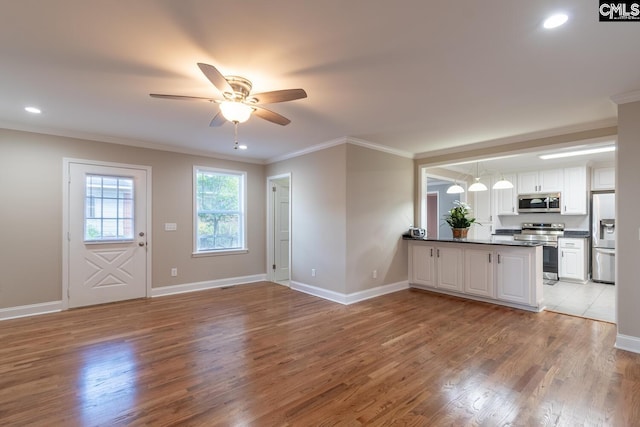 unfurnished living room featuring ceiling fan, light hardwood / wood-style floors, and ornamental molding