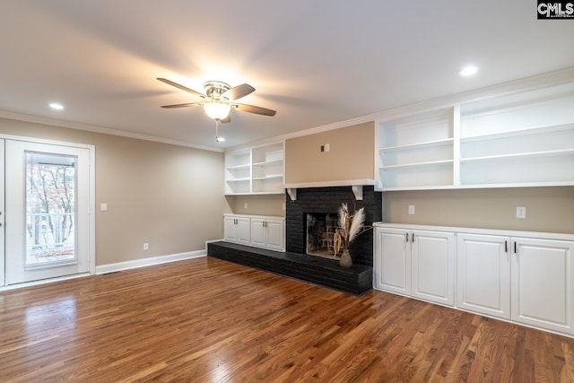 unfurnished living room featuring hardwood / wood-style floors, a fireplace, ornamental molding, and ceiling fan