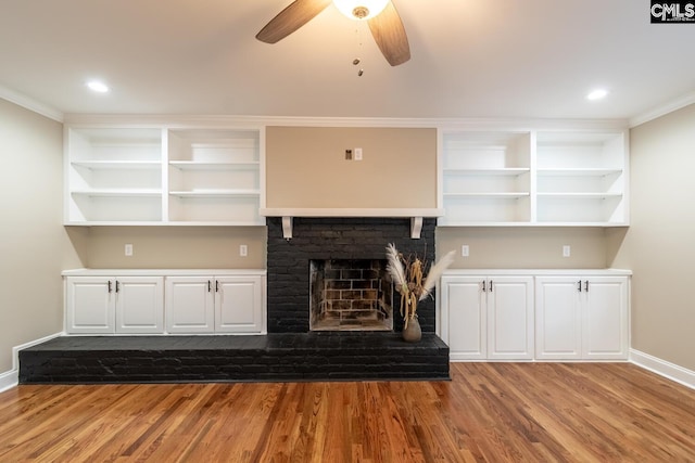 unfurnished living room with a fireplace, light wood-type flooring, ceiling fan, and ornamental molding