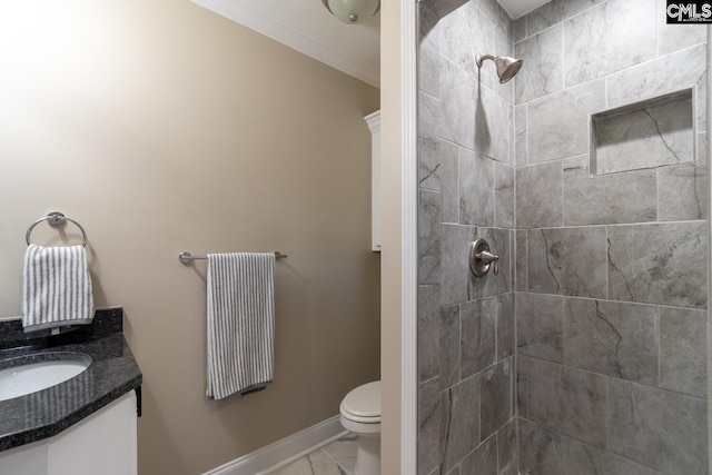 bathroom featuring toilet, vanity, and tiled shower