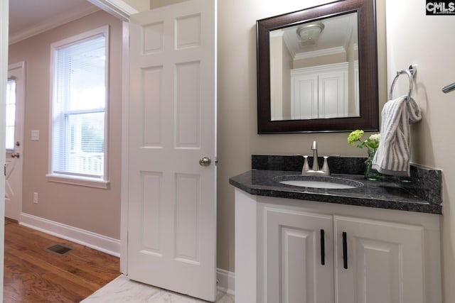 bathroom featuring ornamental molding, plenty of natural light, and wood-type flooring