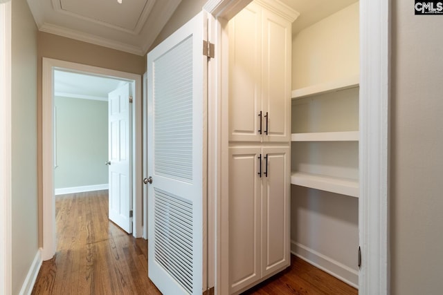 corridor with ornamental molding and dark hardwood / wood-style flooring