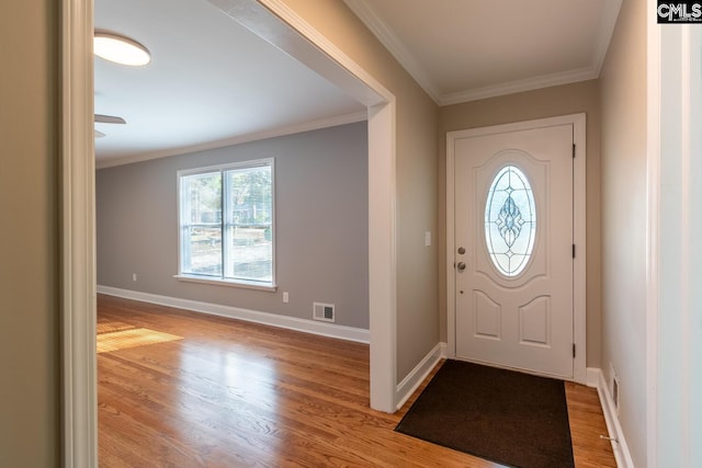 foyer with light wood-type flooring and crown molding