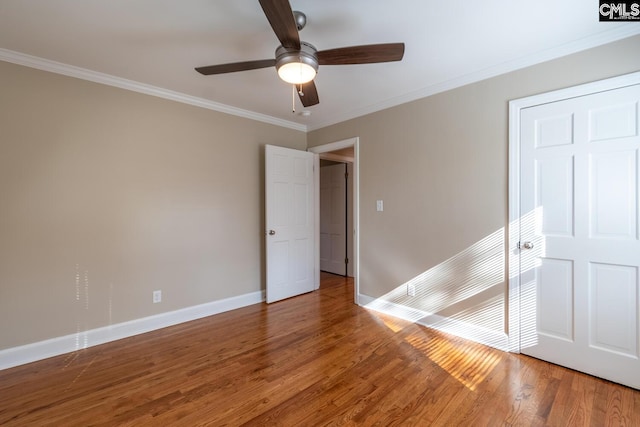 empty room featuring hardwood / wood-style floors, ornamental molding, and ceiling fan