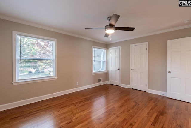 unfurnished bedroom featuring multiple windows, ceiling fan, and crown molding