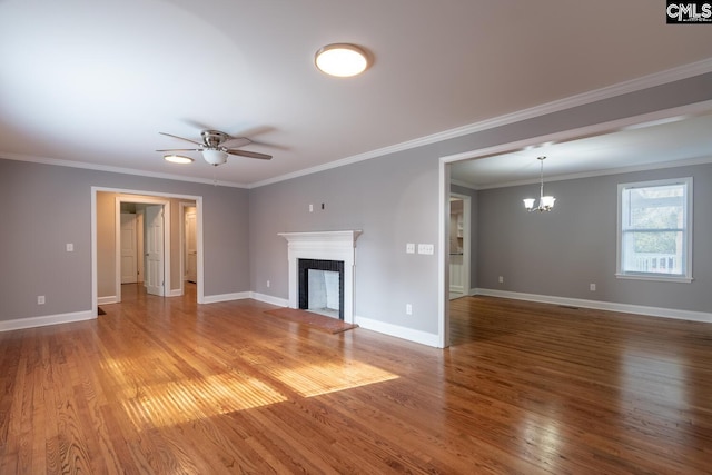 unfurnished living room with ceiling fan with notable chandelier, wood-type flooring, a fireplace, and ornamental molding