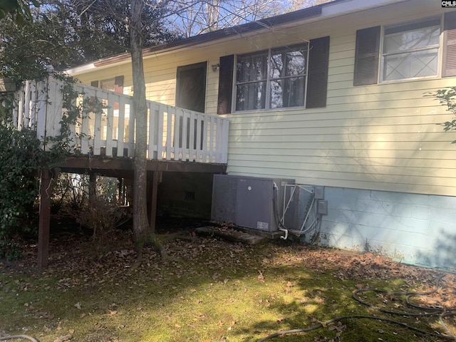 back of property with cooling unit and a yard