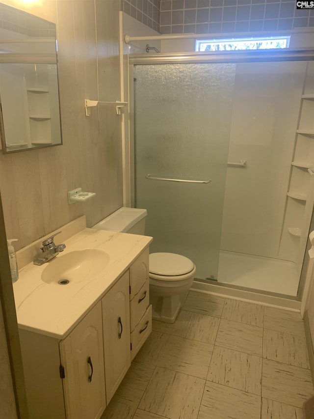 bathroom featuring toilet, an enclosed shower, and vanity