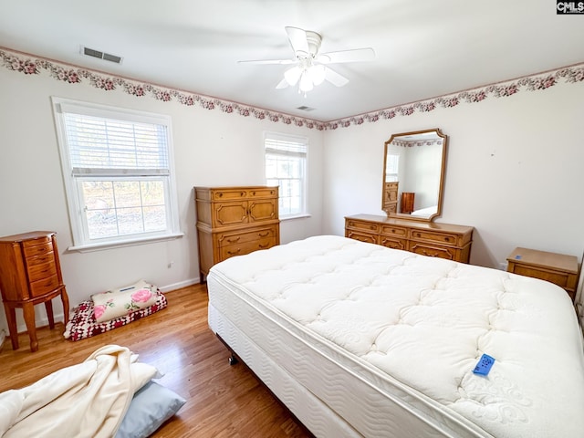 bedroom with light wood-type flooring, ceiling fan, and multiple windows