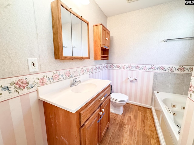 bathroom featuring a bathtub, hardwood / wood-style floors, vanity, and toilet