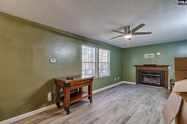 office with a textured ceiling, ceiling fan, and light hardwood / wood-style flooring