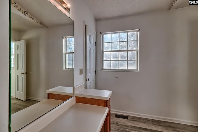 bathroom featuring a textured ceiling and hardwood / wood-style flooring