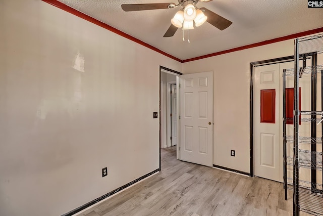 unfurnished bedroom with a closet, ceiling fan, ornamental molding, a textured ceiling, and light hardwood / wood-style flooring