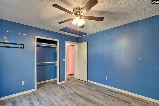 unfurnished bedroom with a closet, a textured ceiling, ceiling fan, and light wood-type flooring