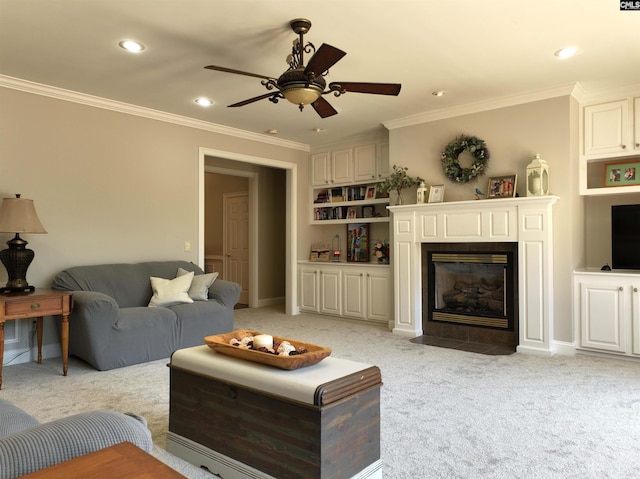 carpeted living room with a fireplace, ceiling fan, and ornamental molding