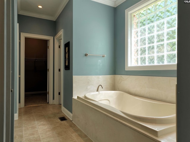 bathroom featuring tile patterned floors, ornamental molding, and a bath