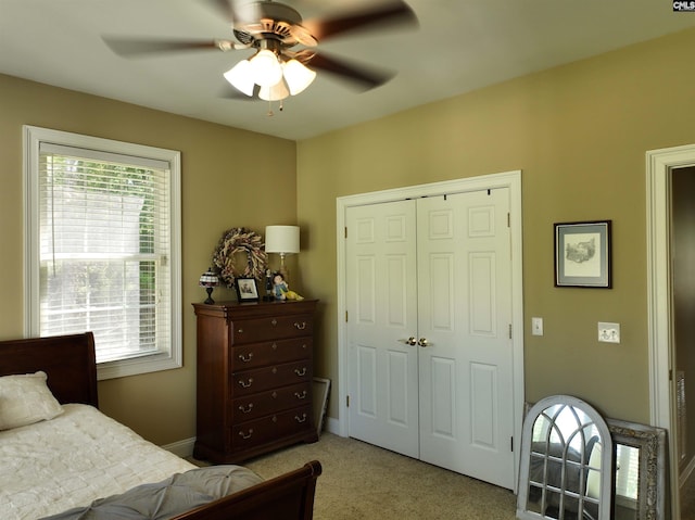 carpeted bedroom featuring ceiling fan and a closet