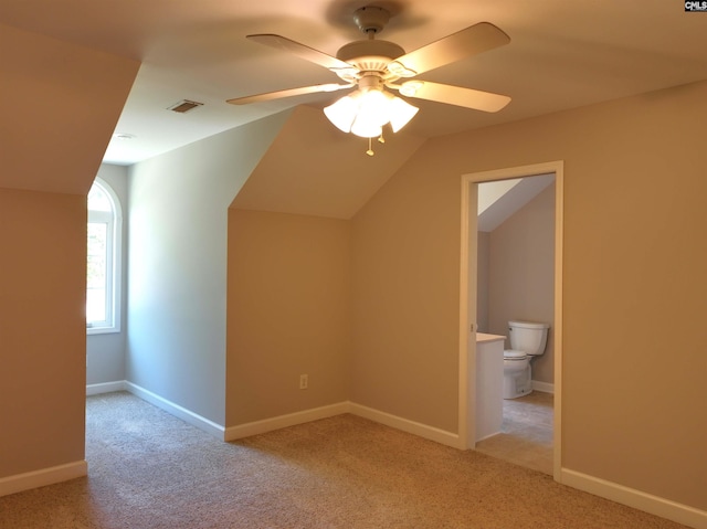 additional living space featuring ceiling fan, light colored carpet, and vaulted ceiling