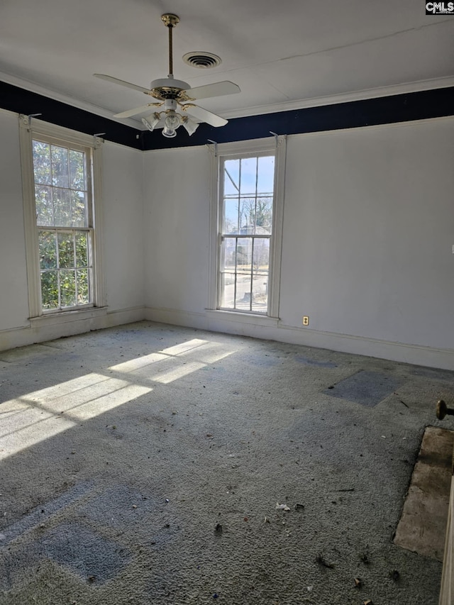 empty room featuring carpet floors, ceiling fan, and a healthy amount of sunlight