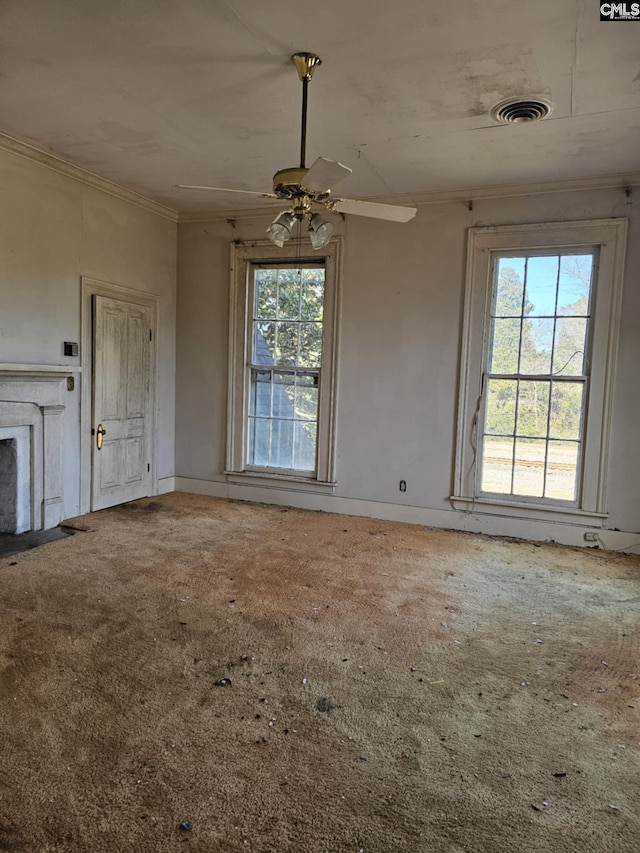 unfurnished living room with carpet floors, ceiling fan, and crown molding