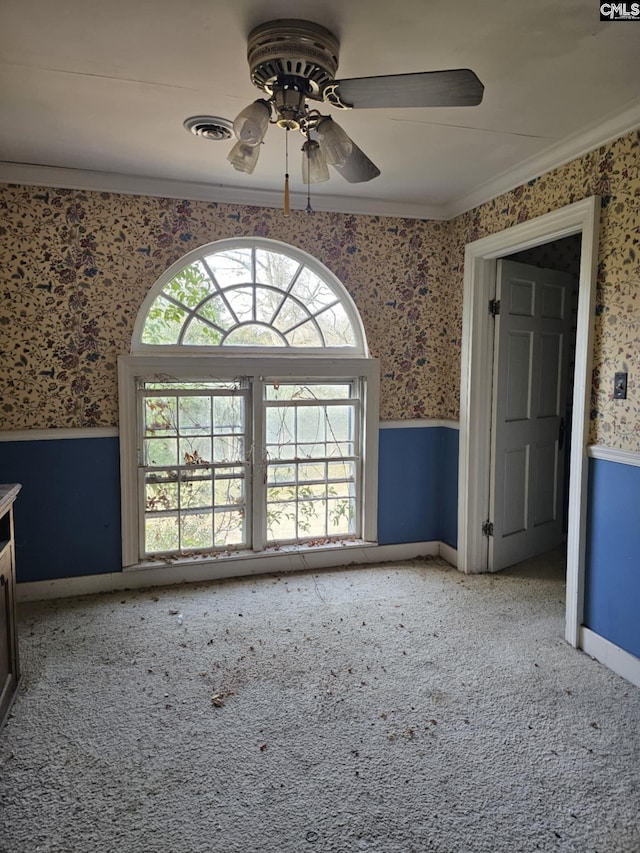 carpeted empty room featuring ceiling fan and crown molding