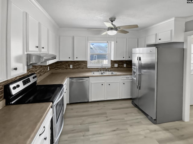 kitchen with stainless steel appliances, white cabinets, sink, and ceiling fan