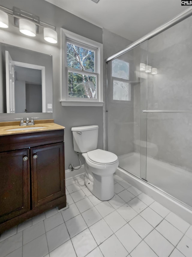 bathroom featuring toilet, tile patterned floors, walk in shower, and vanity