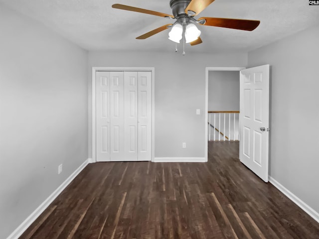 unfurnished bedroom with ceiling fan, dark hardwood / wood-style flooring, and a closet