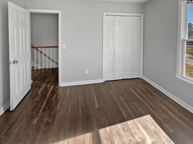 unfurnished bedroom featuring a closet and dark hardwood / wood-style floors