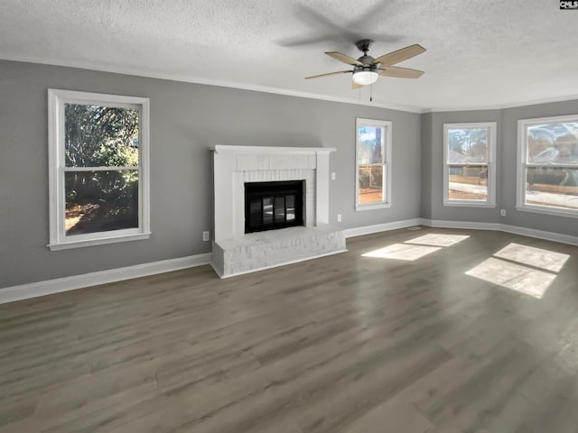 unfurnished living room featuring ceiling fan, dark hardwood / wood-style floors, plenty of natural light, and a fireplace