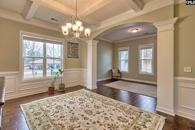 interior space with crown molding, ornate columns, coffered ceiling, and a wealth of natural light