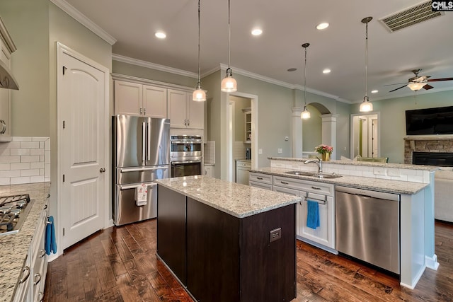 kitchen featuring sink, decorative light fixtures, a kitchen island, and appliances with stainless steel finishes