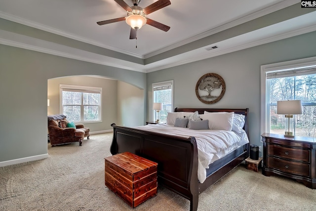 bedroom with crown molding, carpet flooring, ceiling fan, and a tray ceiling