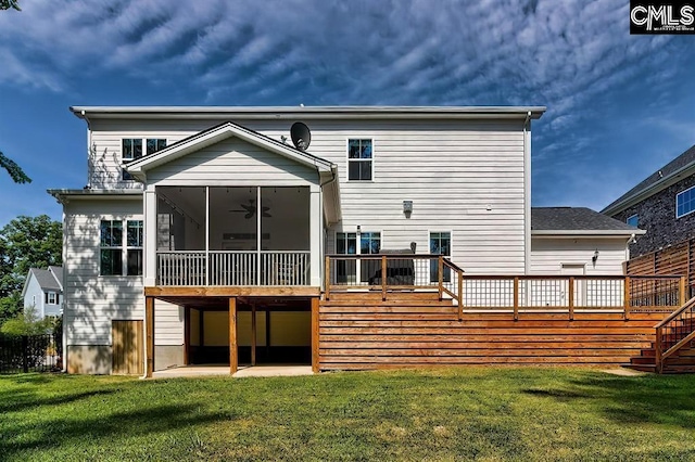 back of house featuring ceiling fan, a deck, a sunroom, and a lawn