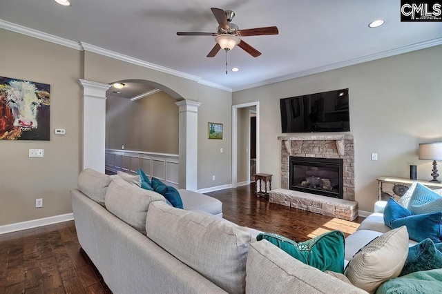 living room featuring crown molding, ceiling fan, dark wood-type flooring, and decorative columns