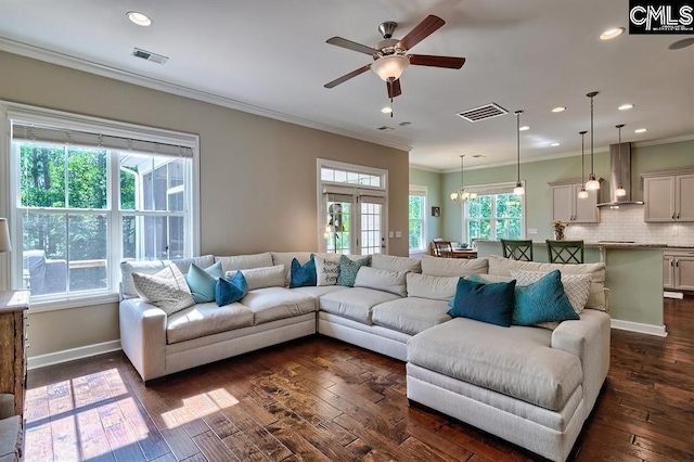 living room with ornamental molding, dark hardwood / wood-style floors, and ceiling fan with notable chandelier