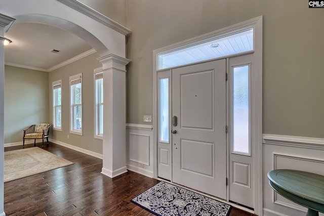 foyer with dark hardwood / wood-style floors, ornamental molding, and decorative columns