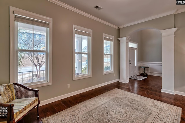 interior space featuring ornamental molding, dark hardwood / wood-style flooring, and decorative columns