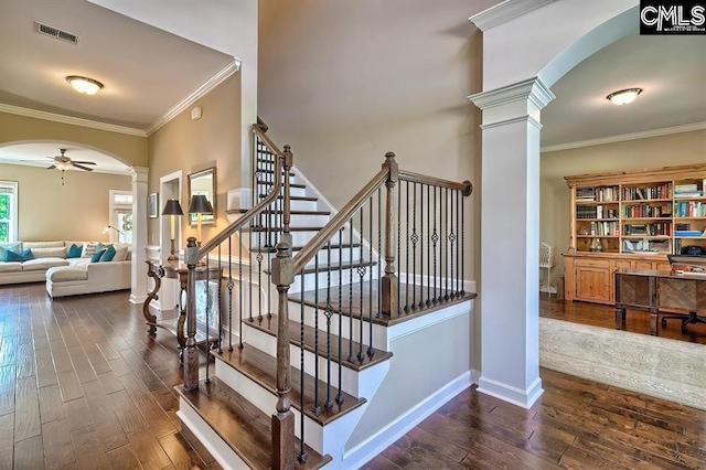 staircase with hardwood / wood-style flooring, ceiling fan, crown molding, and ornate columns