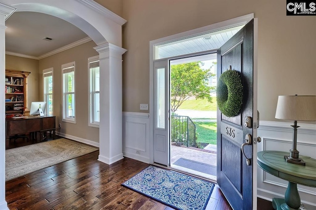 foyer entrance featuring ornate columns, crown molding, and dark wood-type flooring