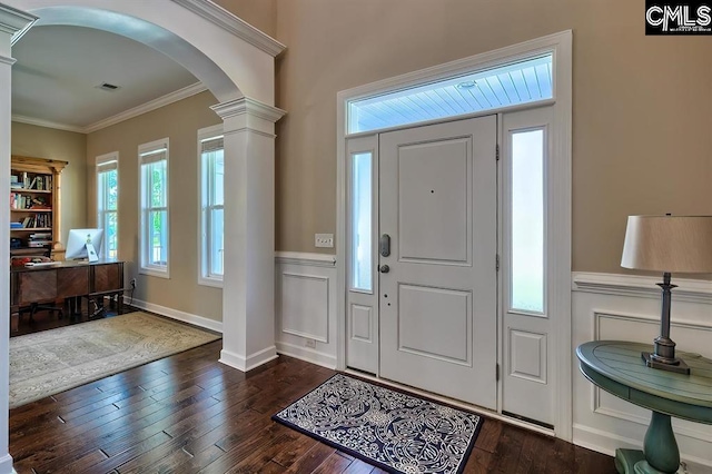 entrance foyer featuring ornamental molding, dark hardwood / wood-style flooring, and decorative columns