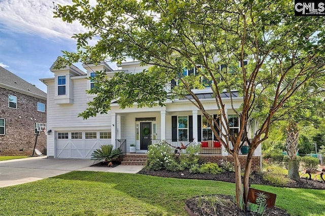 view of front of property featuring a garage, a front yard, and a porch