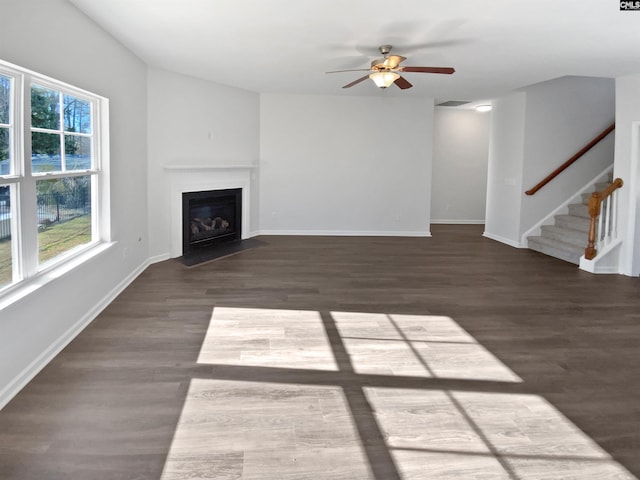 unfurnished living room with dark wood-type flooring and ceiling fan