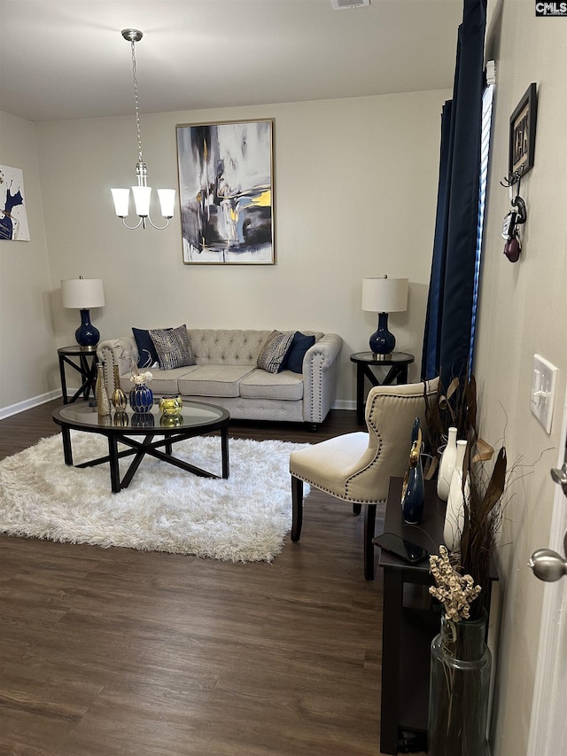 living room with a notable chandelier and dark hardwood / wood-style flooring