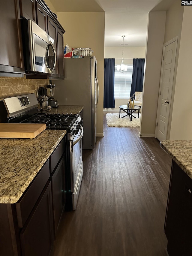 kitchen with light stone counters, pendant lighting, a chandelier, appliances with stainless steel finishes, and dark brown cabinets