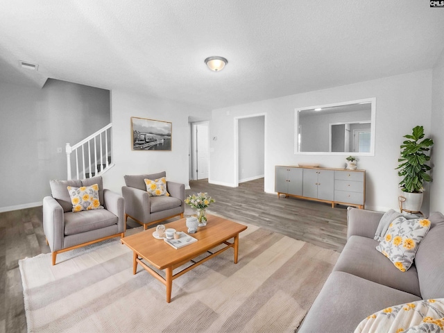 living room with wood-type flooring and a textured ceiling