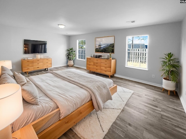 bedroom with hardwood / wood-style floors and multiple windows