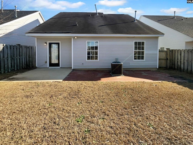 back of property with a lawn, central AC unit, and a patio area